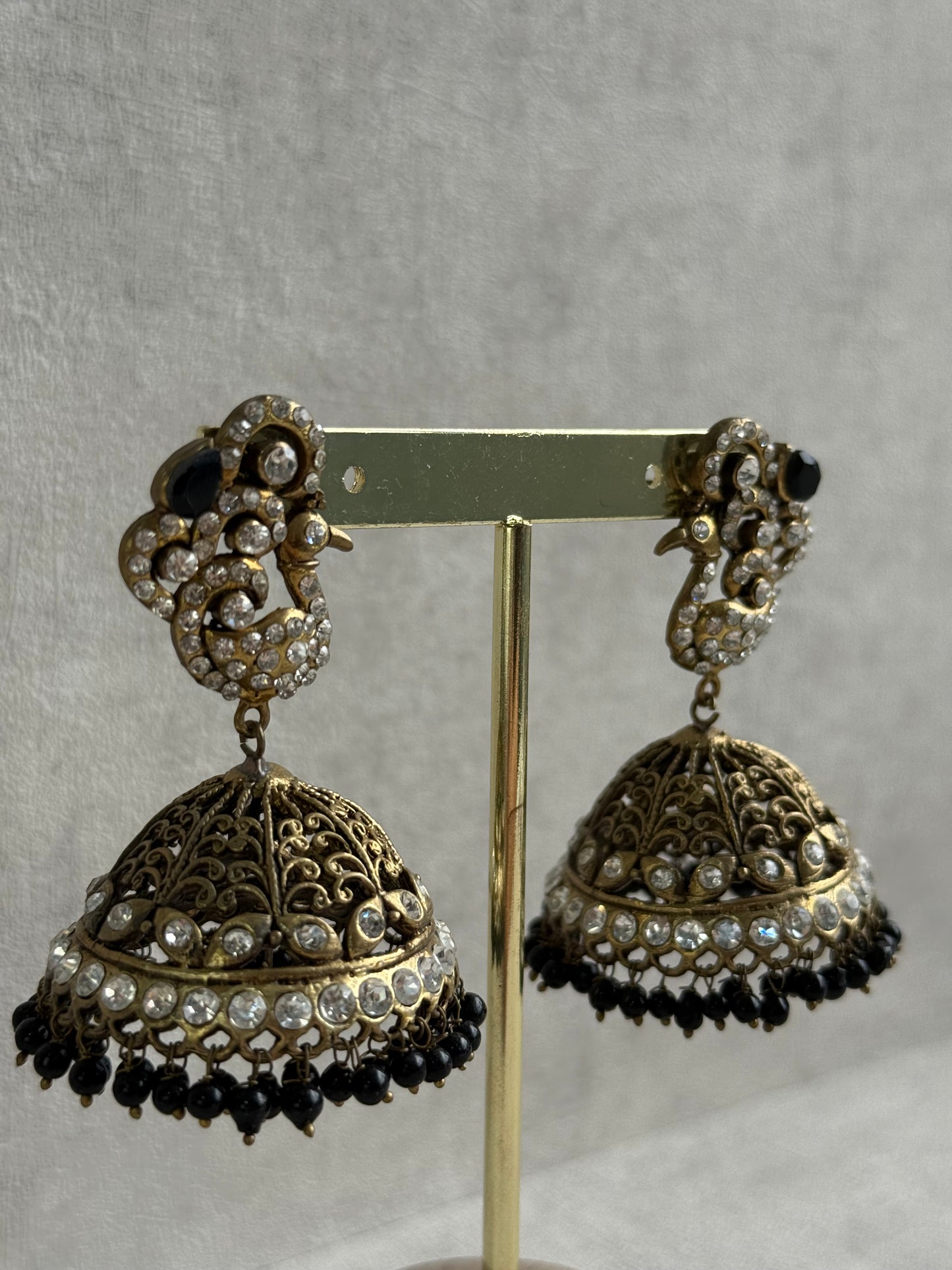 Ayura Designs Mayurika Jhumkis – Antique Gold Jhumkis with Crystal Stones, Black Beads & Peacock Motif