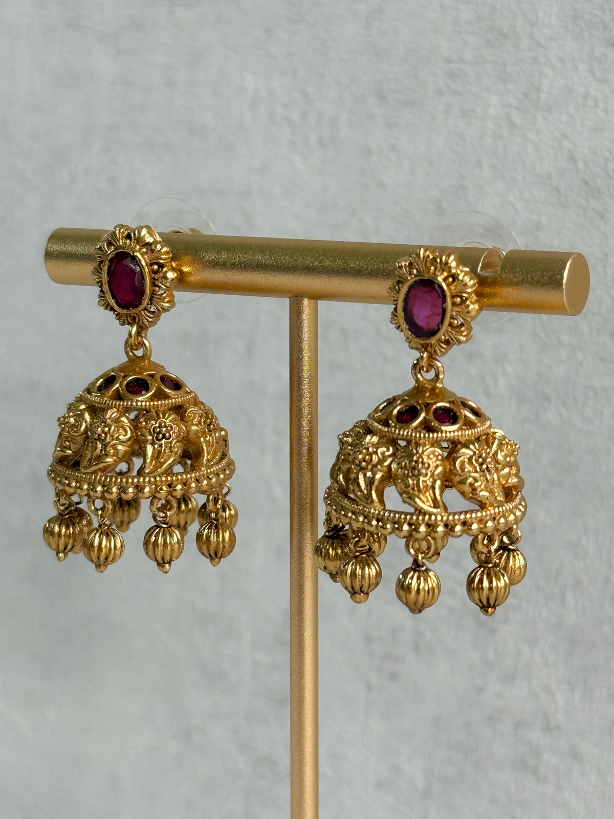 Ayura Designs Savya Jhumkis – Rani Pink Stones, Floral Motifs & Antique Gold Finish