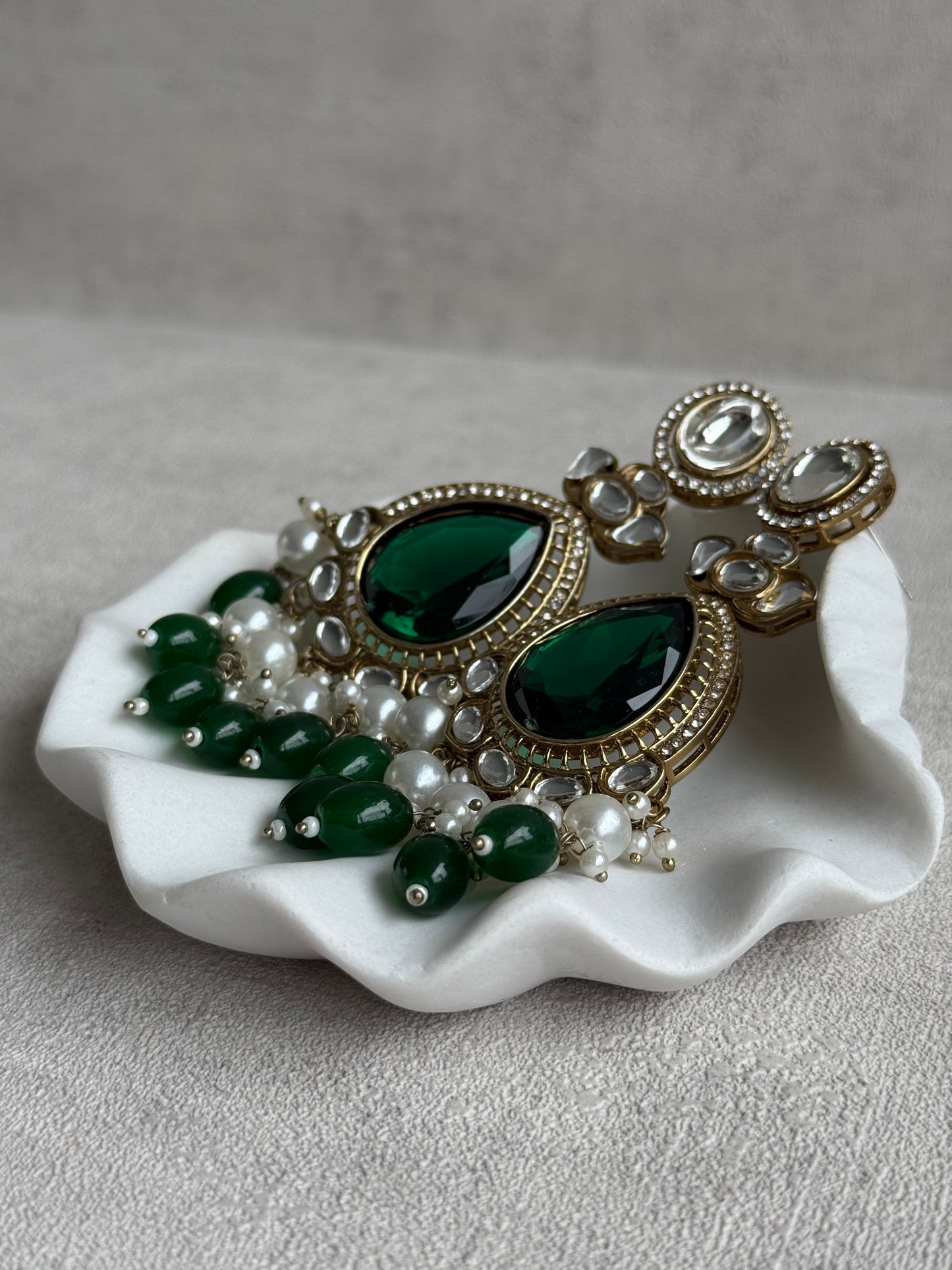 Ayura Designs Nageen Earrings – Antique Gold Jhumkis with Emerald Green Stones, Mirror-Cut Accents & Pearl Drops