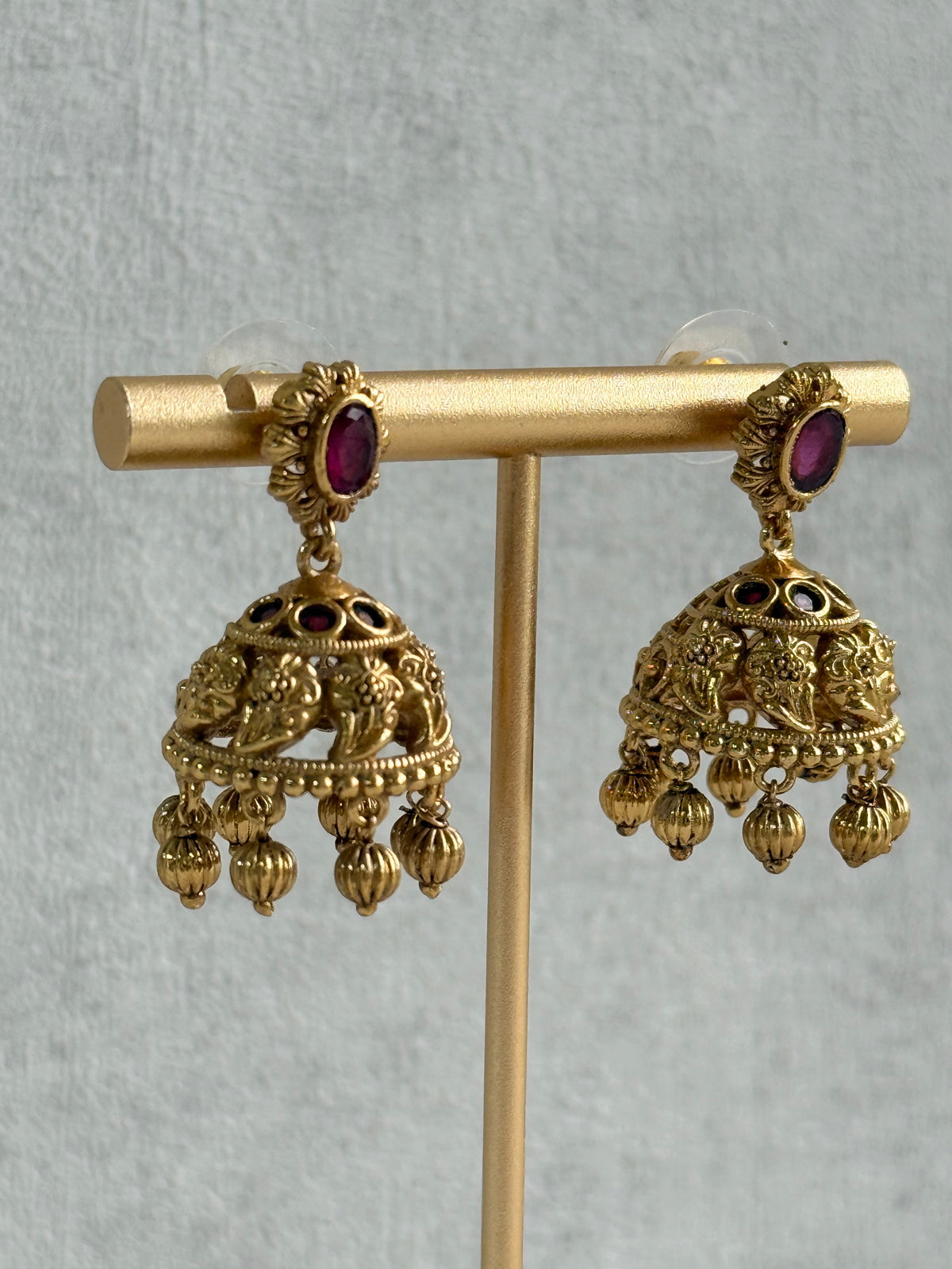 Ayura Designs Savya Jhumkis – Rani Pink Stones, Floral Motifs & Antique Gold Finish