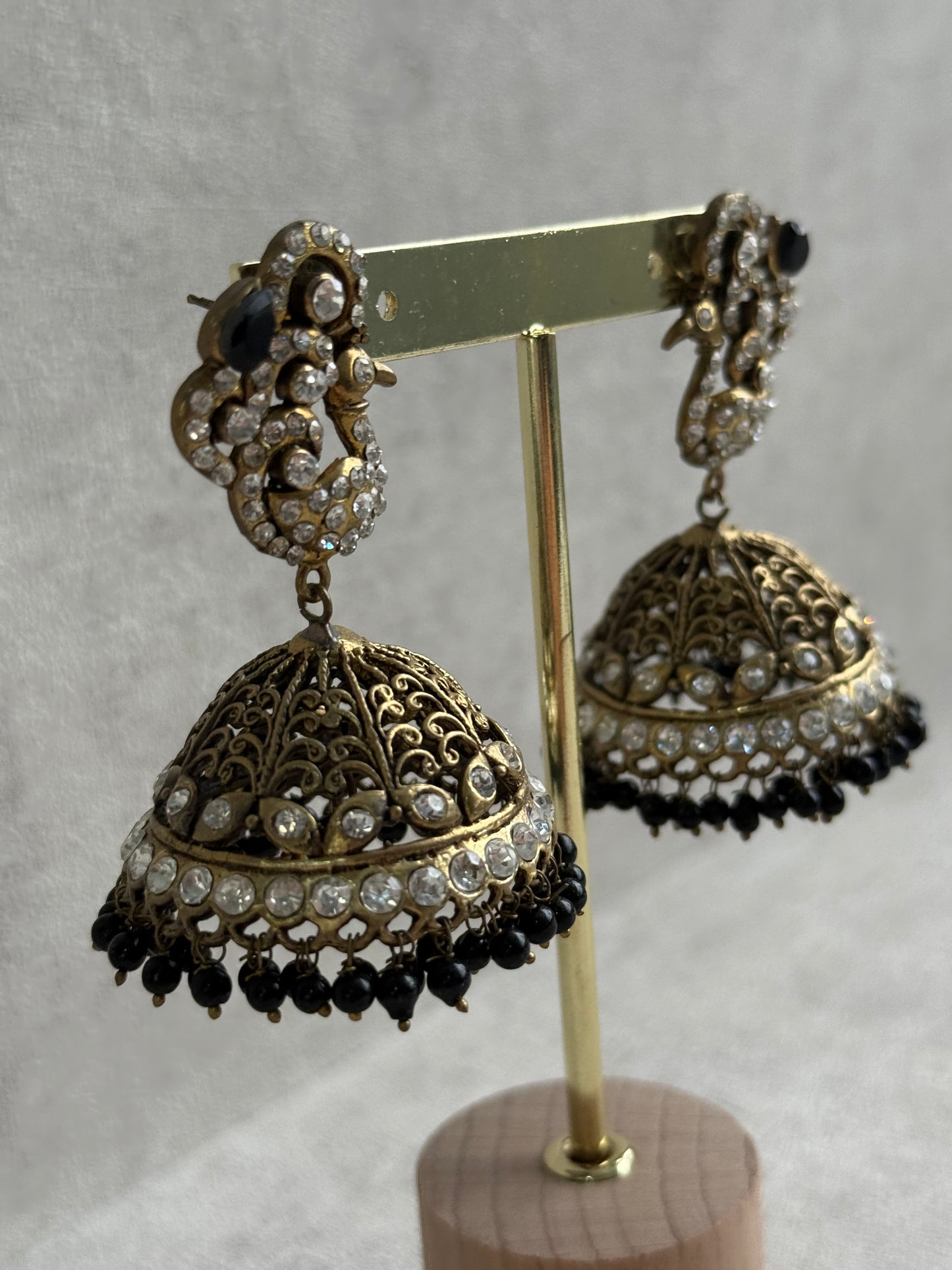 Ayura Designs Mayurika Jhumkis – Antique Gold Jhumkis with Crystal Stones, Black Beads & Peacock Motif