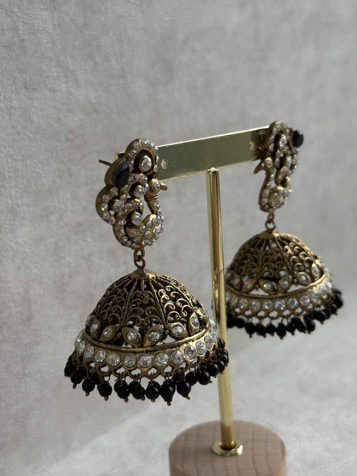 Ayura Designs Mayurika Jhumkis – Antique Gold Jhumkis with Crystal Stones, Black Beads & Peacock Motif