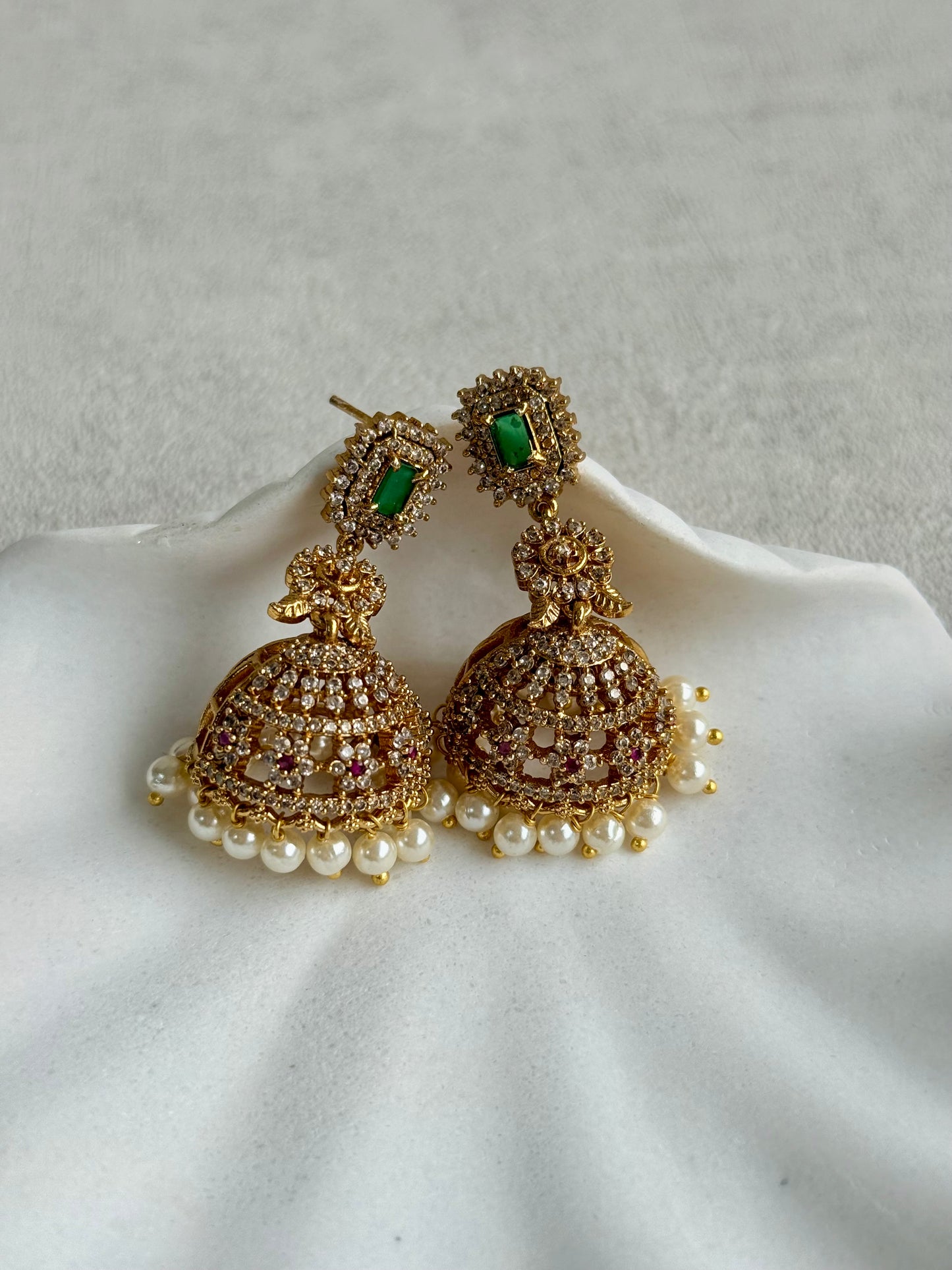 Ayura Designs Maya Jhumkis – Gold Jhumkis with Emerald Green Studs, Pink Stones, Crystal Detailing & Pearl Drops