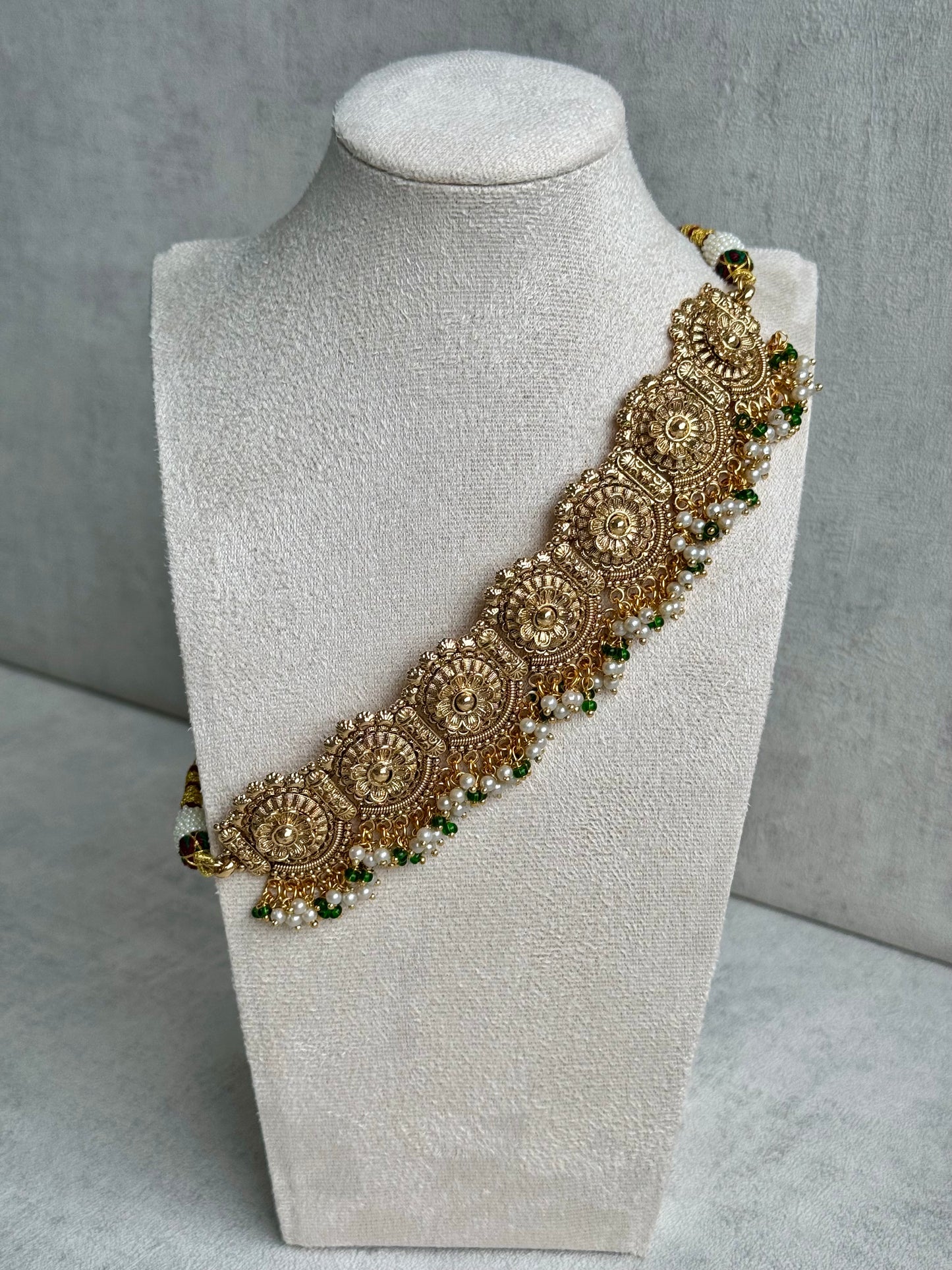 Ayura Designs Nooriya Choker Set with Jhumkis & Tikka: Exquisite Gold-Tone Ensemble Adorned with White & Green Beads