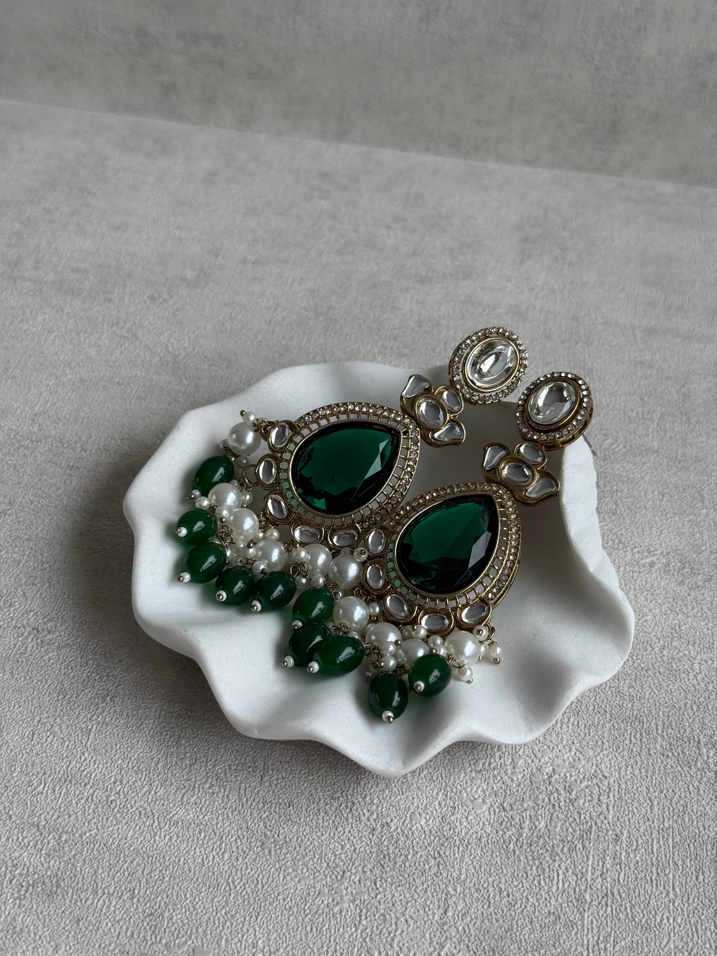Ayura Designs Nageen Earrings – Antique Gold Jhumkis with Emerald Green Stones, Mirror-Cut Accents & Pearl Drops