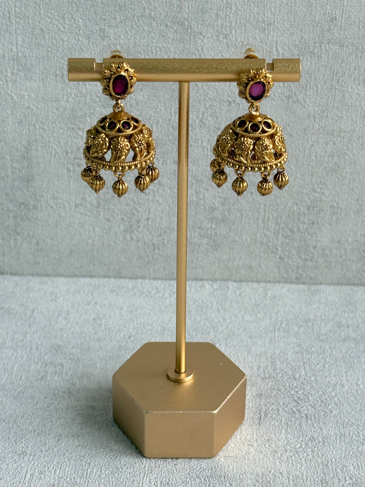 Ayura Designs Savya Jhumkis – Rani Pink Stones, Floral Motifs & Antique Gold Finish