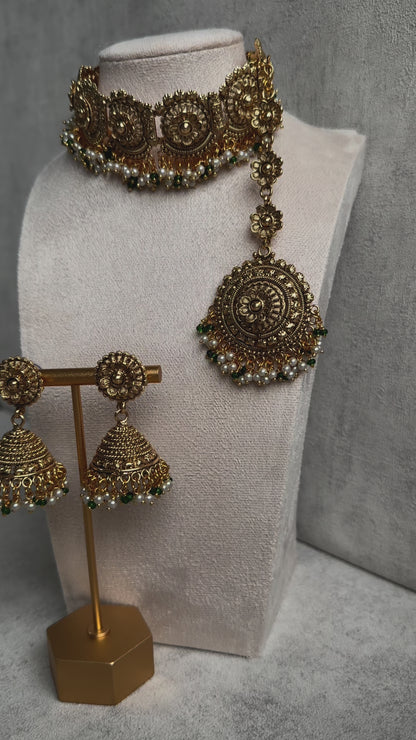 Ayura Designs Nooriya Choker Set with Jhumkis & Tikka: Exquisite Gold-Tone Ensemble Adorned with White & Green Beads